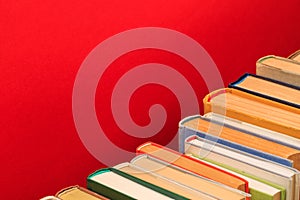 Simple composSimple composition of hardback ition of hardback books, raw of books on wooden deck table and red background - Image.