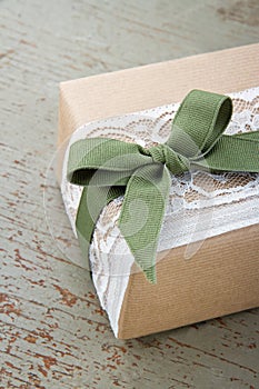 Simple decorative gift box wrapped in brown eco paper and lace