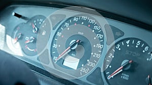 A simple dusty old speedometer in a generic motionless stopped car interior, object detail, closeup, vehicle dashboard dials