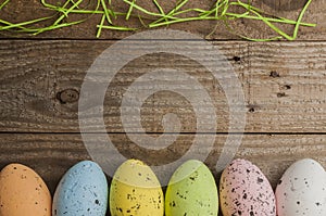 Simple easter background: colored easter eggs on a wooden table