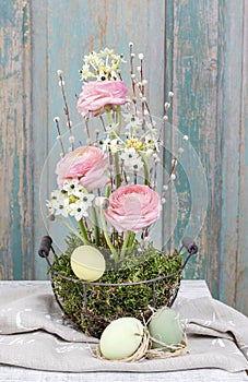 Simple easter floral arrangement with arabian star ornithogalum arabicum, ranunculus flowers, moss and catkins