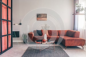 Simple, elegant living room interior with red furniture and an oil painting on white wall