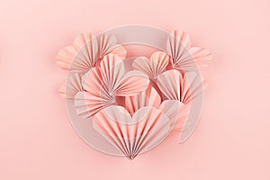 Simple elegant pink paper heart of flying little ribbed hearts on cute pink color - Valentine day background, top view, copy space