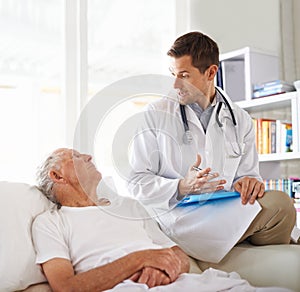 Simple explanation. a handsome male doctor explaining something to an elderly patient.