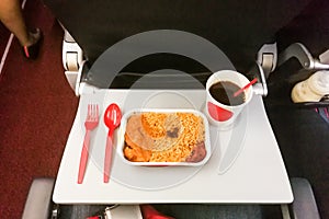 Simple in-flight meal of rice, meat, coffee in disposable utensils