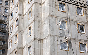 Simple generic new real estate building left unfinished, detail, block of flats, raw concrete walls, windows. Construction site