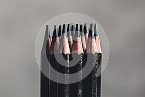 Simple graphite pencils on grey background. Black pencils