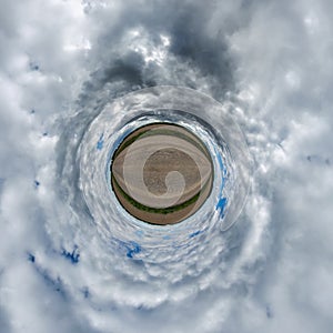 simple green tiny planet without buildings in blue sky with beautiful clouds. Transformation of spherical panorama 360 degrees.