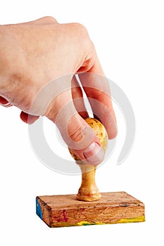 Simple hand stamp gesture, old traditional wooden stamp in hand isolated on white, cut out. Pressing stamp against the paper