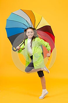 Simple happiness. I do not care. Carefree schoolgirl jumping with umbrella waterproof rain coat. Autumn rain. Rainy days