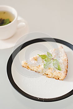 Simple homemade apple pie with powdered sugar and fresh mint