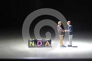 Simple Illustration Photo, NDA, No Disclosure Agreement, Two Man Handshaking make a Illegal Business Agreement, with Handcuff