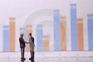 Simple Illustration Photo for Silhouette Two Man Handshaking for Business Agreement with graphic Chart as a background