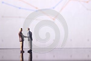 Simple Illustration Photo for Silhouette Two Man Handshaking for Business Agreement with graphic Chart as a background