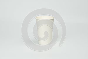 A simple image of a white coffee cup on an indistinct tablecounter, set against a subtle gradient backdrop. photo