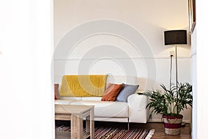 Jednoduchý průmyslový z obývací pokoj dřevěný stůl stojící před šedá pohovka modrý polštáře 
