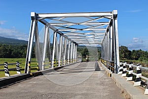 A Simple Iron Bridge Thats Is Often Passed By The West Satarmese People To Carry Out Their Economic Activities photo