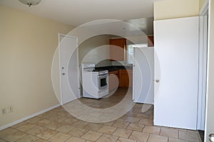 Simple kitchen with range, cabinets, refrigerator, tile floor