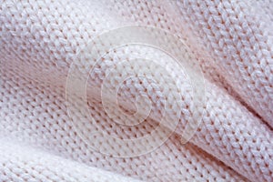 Simple knitted fabric made of pink yarn with large folds