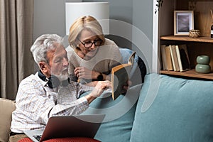 Simple living. Elderly retired couple enjoying their retirement, reminiscing entertaining in their warm home. Senior people