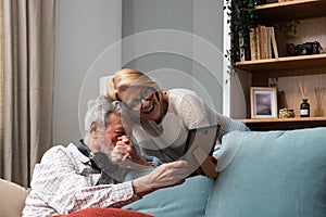 Simple living. Elderly retired couple enjoying their retirement, reminiscing entertaining in their warm home. Senior people