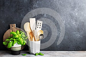 Simple minimalist kitchen shelf. Cutlery, kitchen tools, greens in a glass, fruits on a light background. Scandy style