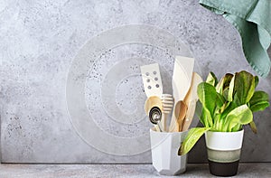 Simple minimalist kitchen shelf. Cutlery, kitchen tools, greens in a glass, fruits on a light background. Scandy style