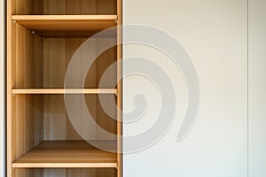 Simple minimalistic storage shelves made of wooden particleboard material, empty shelf as copy space photo