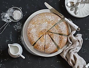 Simple orange cake with olive oil on a dark stone background.