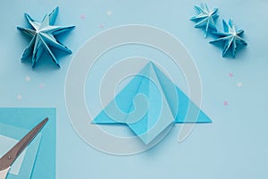 Simple origami 3D Christmas tree made from blue paper. Step by step instruction, step 11