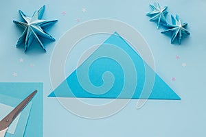 Simple origami 3D Christmas tree made from blue paper. Step by step instruction, step 2