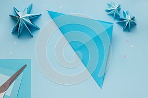 Simple origami 3D Christmas tree made from blue paper. Step by step instruction, step 3