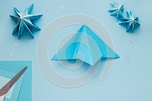 Simple origami 3D Christmas tree made from blue paper. Step by step instruction, step 9