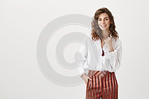 Simple outfit speaks loudest. Portrait of emotive charming adult woman with trendy hairstyle and fancy striped pants