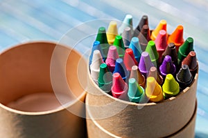 A simple pack, set of colorful wax crayons, multi colored crayon tube container object closeup, detail. Creativity, creative arts