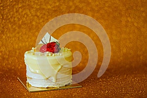 Simple party concept: small cake, golden glitter background, free copy space