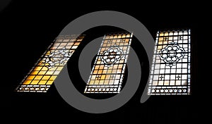 Simple patterned antique stained glass window silhouettes frame on black background in The national gallery