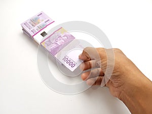 Simple Photo Conceptual, Top View Caucassian Right Man Hand Picking one sheet 10000 Rupiah Indonesia Paper Money at white
