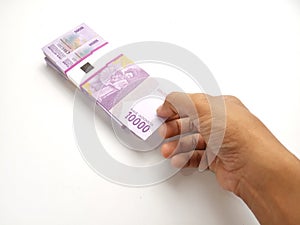 Simple Photo Conceptual, Top View Caucassian Right Man Hand Picking one sheet 10000 Rupiah Indonesia Paper Money at white