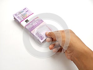 Simple Photo Conceptual, Top View Caucassian Right Man Hand Picking one sheet 10000 Rupiah Indonesia Paper Money at white