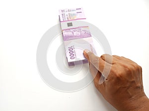 Simple Photo Conceptual, Top View Caucassian Right Man Hand Picking one sheet 10000 Rupiah Indonesia Paper Money at white