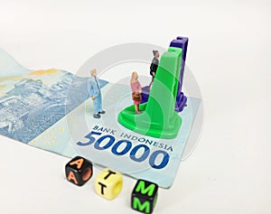 Simple Photo ilustration for Financial Transaction at Automatic Teller Machine, 50000 indonesia rupiah money as a floor, pencil