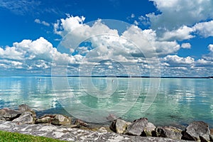 Simple picture about Lake Balaton in Hungary from Badacsony beach with blue sky and cloud refletion on the water photo