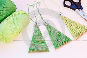 Easy Christmas trees decor on a wooden background. Home Christmas trees decor from old cardboard box and cotton yarn