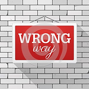 Simple red sign with text `Wrong Way` hanging on a gray brick wall. Grunge brickwork background, textured rough surface.