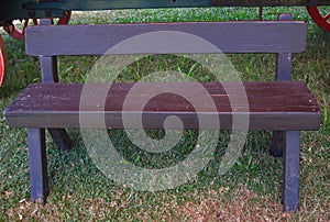 SIMPLE ROBUST WOODEN BENCH STANDING IN FRONT OF AN OLD OX WAGON