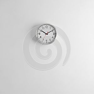 Round Wall Clock with Silver Frame and Black Numbers on a White Wall
