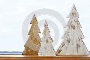 Simple, rustic, country style Christmas holiday home decorations. Handmade painted wood trees on windowsill.