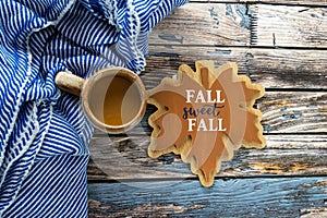 Simple rustic fall autumn arragement with a maple leave expression, striped blanket, coffee cup on a blue wood background