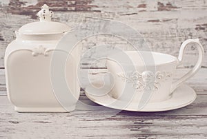 Simple rustic white and blue crockery, empty dishes. Large bowl, cup and porcelain jar with lid. Wooden background, shabby chic